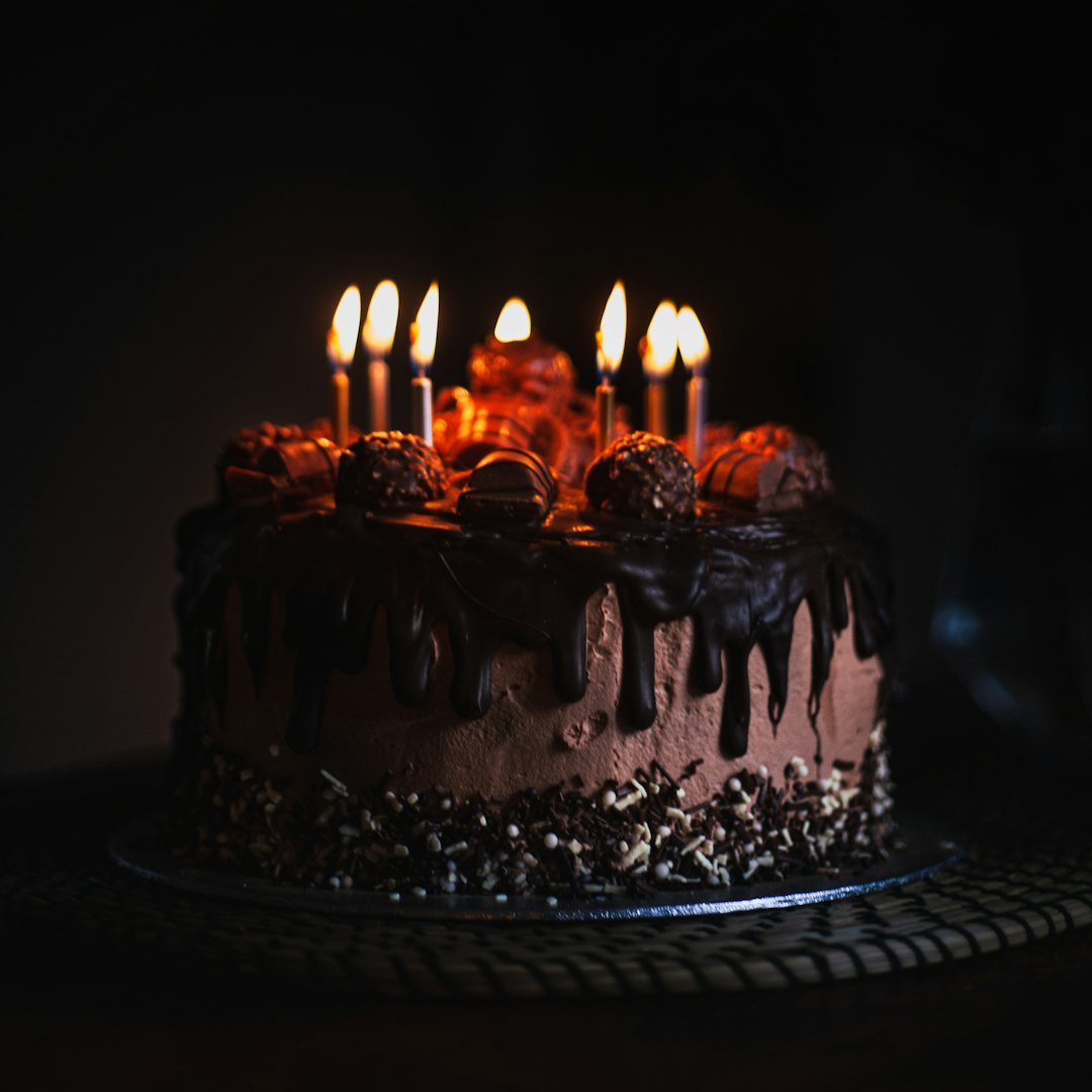 Chocolate cake with lit candles in the dark, spiritual happy birthday blessings