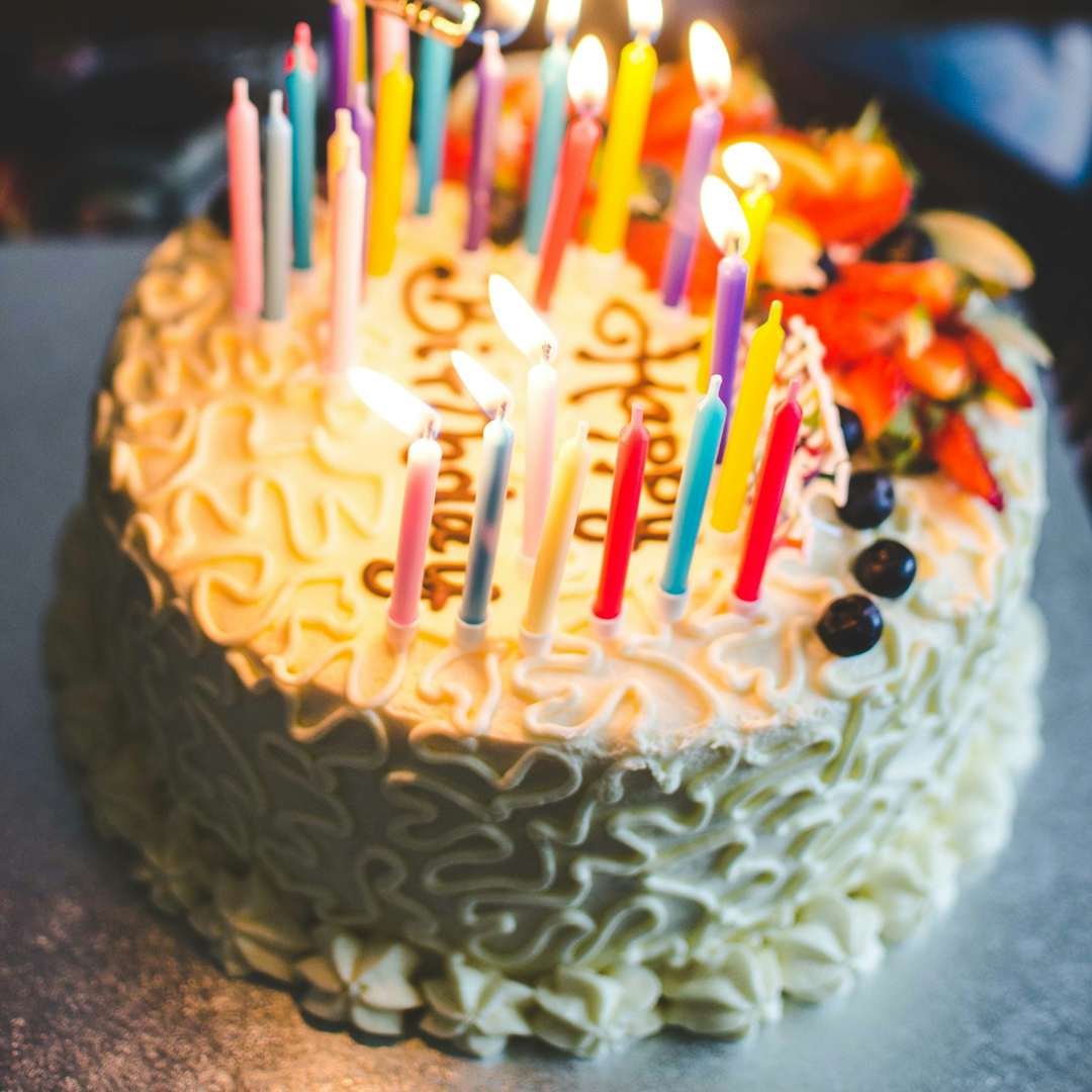 Hand lighting candles on a birthday cake, sweet happy birthday blessings