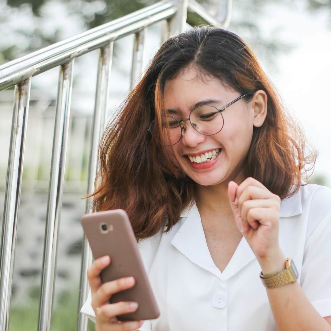 Woman laughing at her phone, funny absolutely pick up lines to break the ice